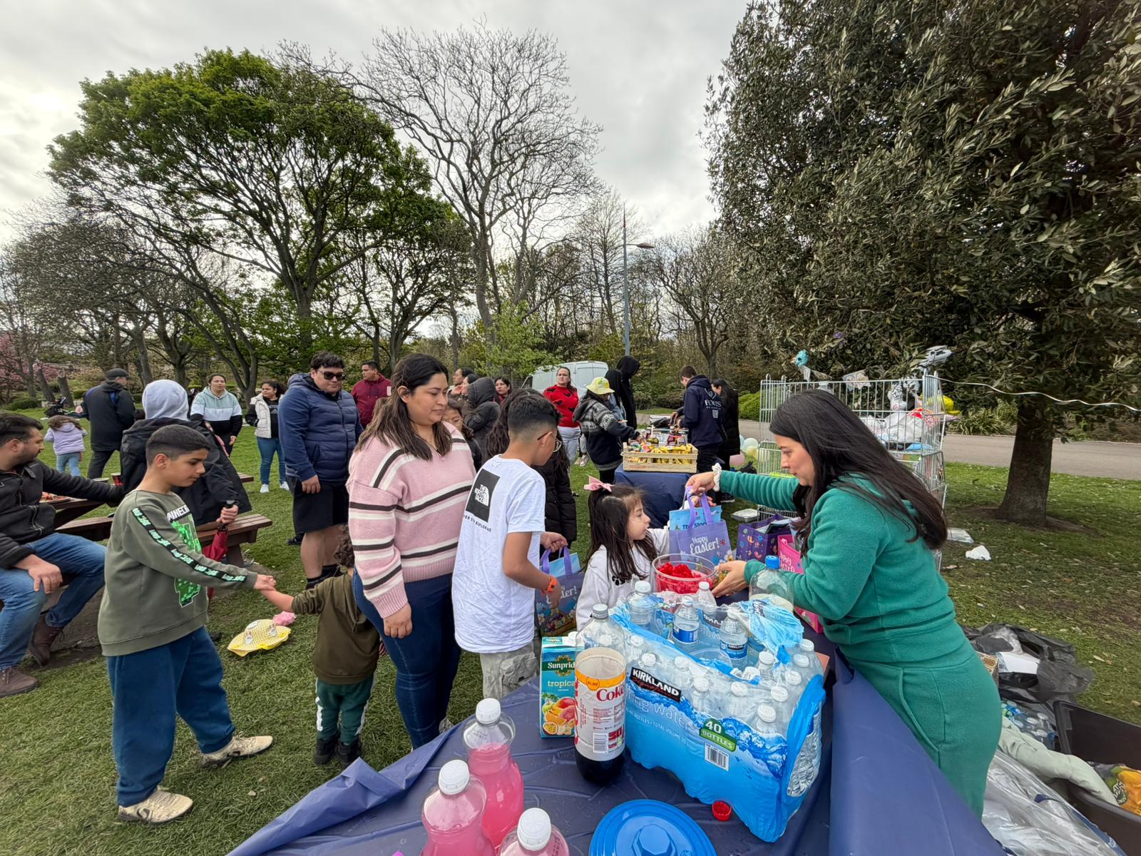 Families and volunteers gathered at an outdoor Roots for Change event