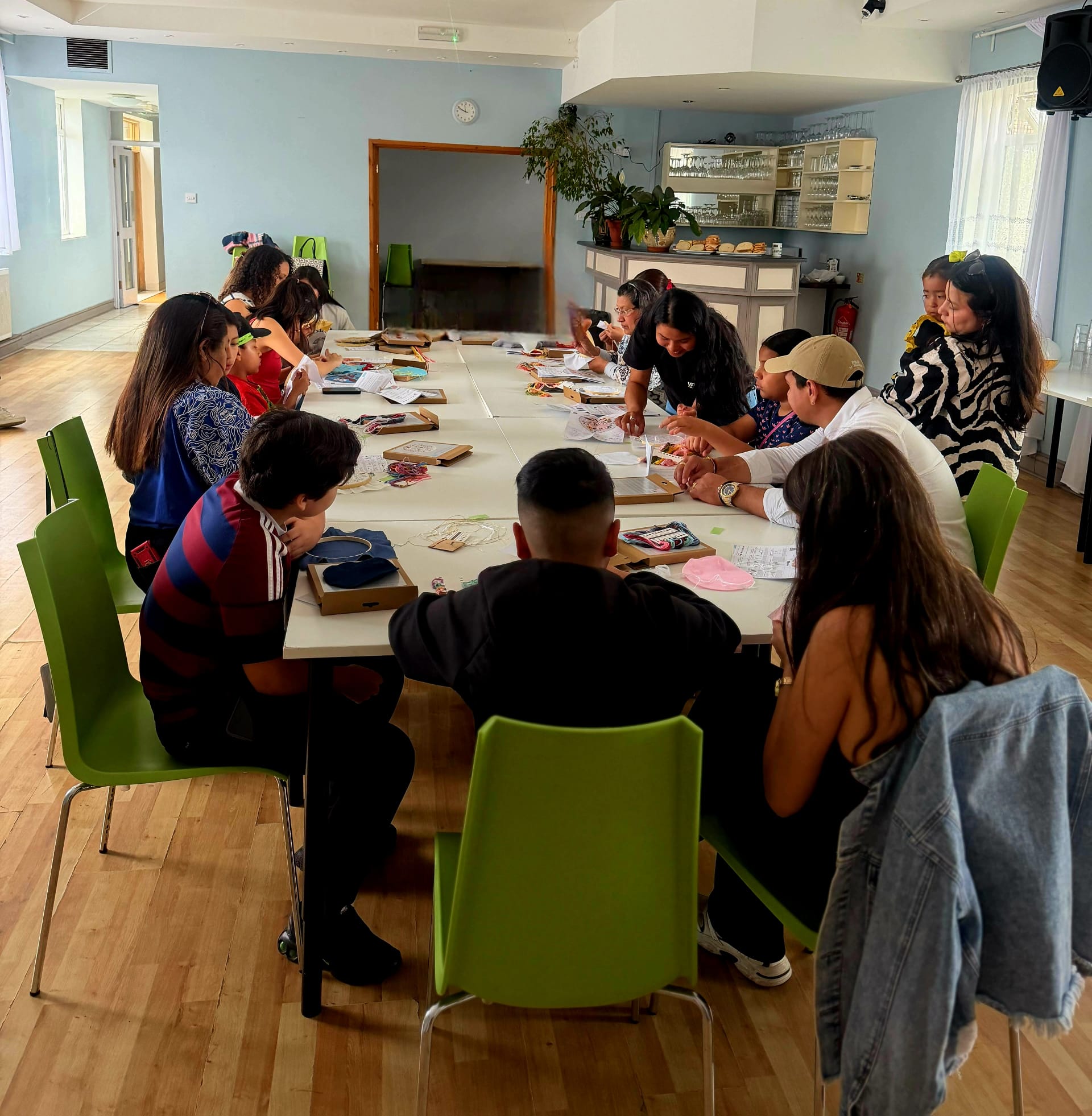 Adults and young people creating embroidery together at Roots for Change