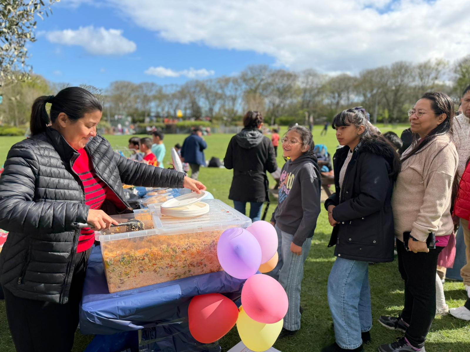 Families receiving food and treats during a Roots for Change Easter event